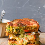 Chutney grilled cheese sandwich with melted mozzarella, cheddar, green chutney, and vegetables